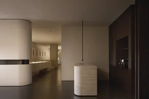 A modern interior space with minimalist design elements featuring concrete and wood materials.