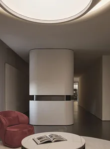 A modern living room with minimalist decor, white marble walls and floor, and a round coffee table.