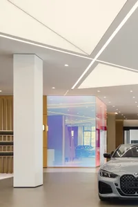 A well-lit, modern car dealership interior with sleek design elements and glass partitions.