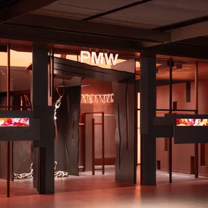 Modern interior design with metal, glass, and wood elements prominently displayed under red lighting.
