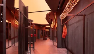 A modern clothing store with metallic textile walls and clothing on racks.