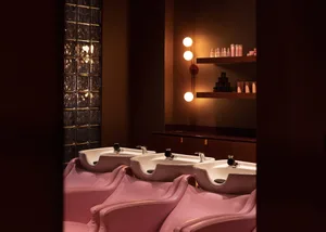 Salon interior with pink leather chairs and white sinks.