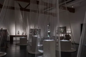An interior design exhibition featuring a curtain made of thin strings hanging from the ceiling.
