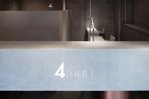 Minimalist office interior featuring concrete, metal, and glass materials.