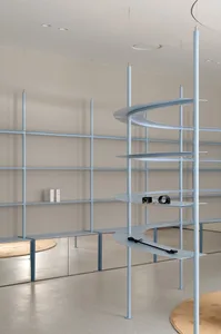 Modern minimalist interior design featuring a sleek, metal shelving unit with clean lines and a curved design.