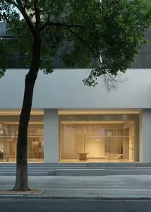 A modern storefront with a concrete facade and large glass windows.