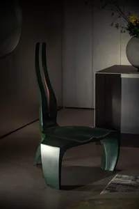A sleek, modern metal stool with a grey finish, featuring curved lines and a unique shape.