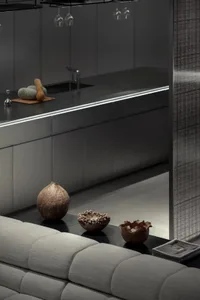 Modern, minimalist kitchen space featuring metallic-grey cabinets, concrete countertops, and metallic accessories.