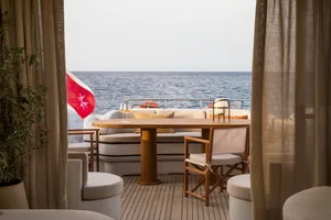 Modern yacht terrace with industrial design elements, featuring wood furniture and leather seating.