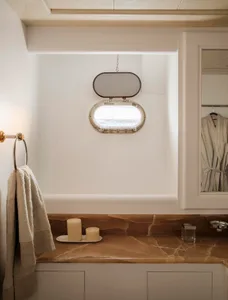 A modern bathroom with a marble countertop and a window with a view of the ocean.