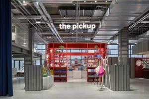 Industrial storefront with red shelving units displaying various items.