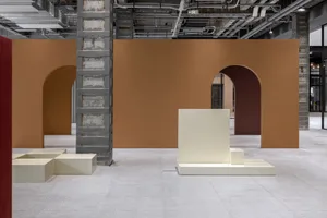 A minimalist interior design featuring concrete elements and an industrial-style structure with arches and exposed piping.