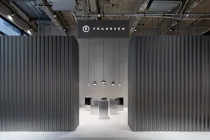 Industrial-style commercial interior with metallic walls and hanging lamps.