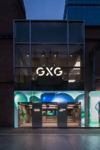 Night view of a modern retail storefront with a glass facade and large windows.