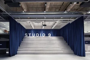A modern, corporate space featuring granite stairs and blue curtains