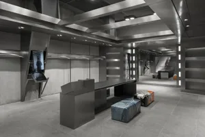 Modern retail space featuring industrial design elements such as metal finishes, concrete walls, and large glass panels.