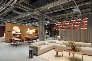 A spacious office lounge featuring modern industrial design elements such as metal, wood, and fabric materials.