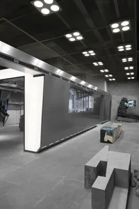 A minimalist atrium with industrial concrete walls and illuminated panels.
