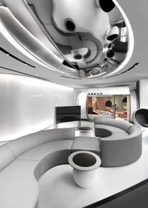 A modern lounge area featuring a circular sofa upholstered in white leather, with stainless steel and glass accessories.
