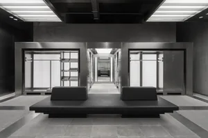 A modern retail shop with sleek metal and concrete elements, features glass display cases.