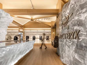 A modern retail store interior featuring wooden structures and glass shelves.