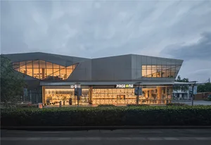 Modern retail storefront with a glass facade, illuminated interior, and exterior space.