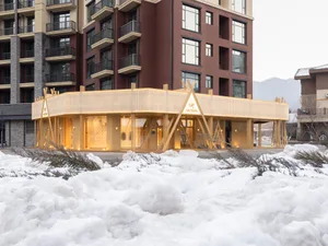 Modern retail storefront with a wooden facade in a snowy landscape.