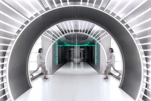 A modern hallway featuring a futuristic metal tunnel with bright lights and green accents, leading to a futuristic room with 