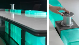 A modern furniture glass counter with integrated electronic ports.