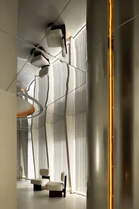 A sleek, modern office lounge area with metallic walls and furniture.