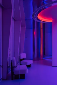 Modern, minimalist interior design featuring metallic glass columns and vibrant lighting.