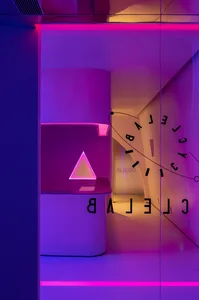 Modern reception desk illuminated with pink neon lights, featuring a triangle-shaped LED light.