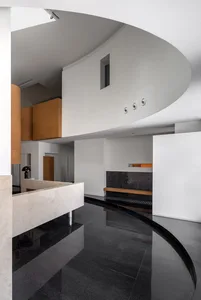 A modern interior design featuring black, concrete flooring and minimalist furniture.