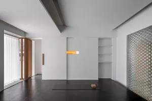 Minimalist living room with neutral tones, featuring a yoga mat and a minimalist design aesthetic.