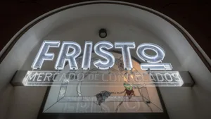 A modern restaurant entrance featuring a illuminated 'FRISTO' sign in neon glass.
