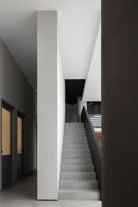A modern interior featuring concrete stairs and dark walls.