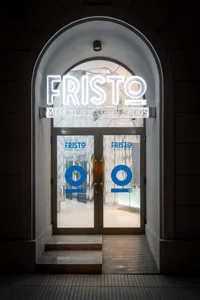 Modern storefront with glass doors and illuminated signage.