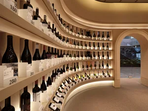A well-stocked wine shop featuring a curved shelf design.