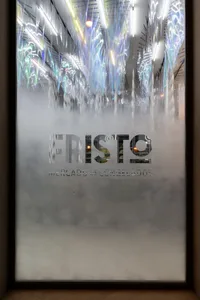 A frosted storefront window with the word 'Fristo' and the words 'Mercado De Congelados' written in frosted glass.