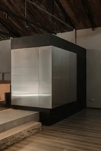 Industrial-style minimalist office lobby with concrete walls and steel elements.