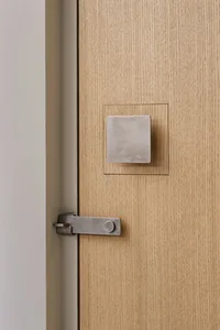 A modern door handle in metal and wood.