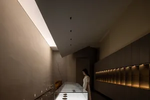 A minimalist exhibition space featuring glass and wooden elements.