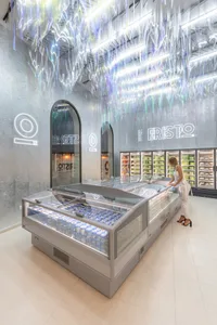 A modern grocery store with metallic surfaces and illuminated displays.