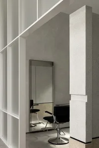 Modern minimalist salon featuring metallic furniture and large mirrors.