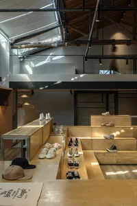 A modern retail shop featuring wooden display shelves and a glass wall.
