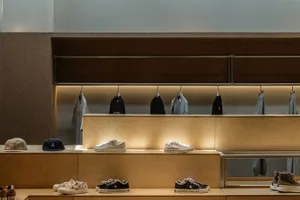A retail shoe store with wooden furniture displaying shoes and clothing.