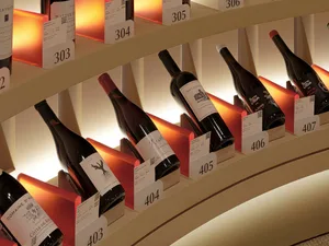 A well-organized wine display featuring red shelf holders and warm lighting.