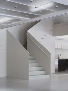 Minimalist modern interior featuring white walls and concrete stairs.