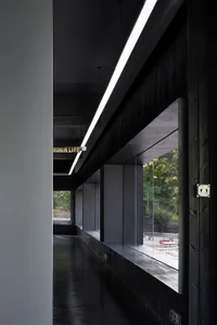 A modern office space featuring black wood elements, with natural light streaming through expansive windows.