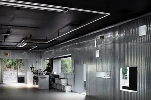 A modern coffee shop interior with metal-clad walls and minimalist design.